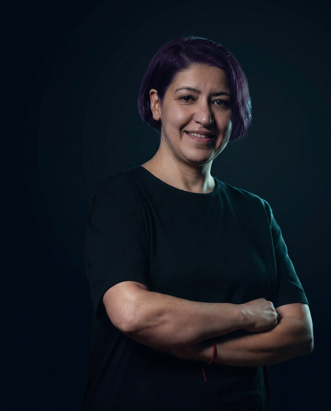 Burcu Celik, tattoo artist, portrait in low teal light
