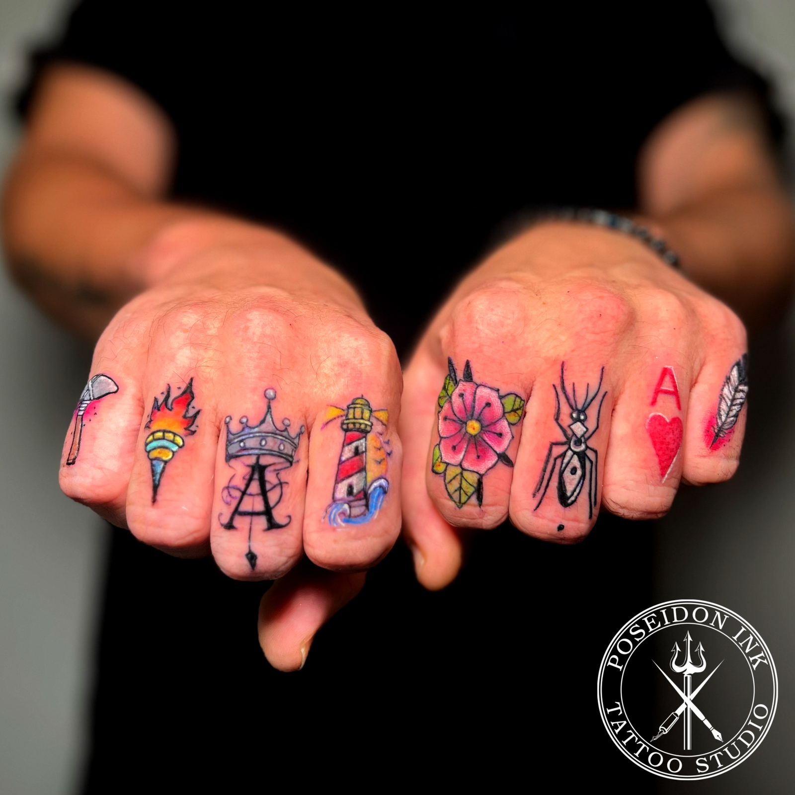 Eight miniature colour finger tattoos including a lighthouse, torch, crowned monogram, flower, spider, ace of hearts and feather